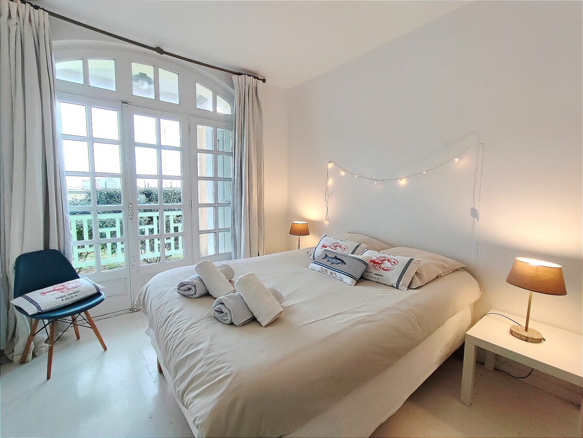 Chambre avec linge de lit blanc préparée pour l'arrivée